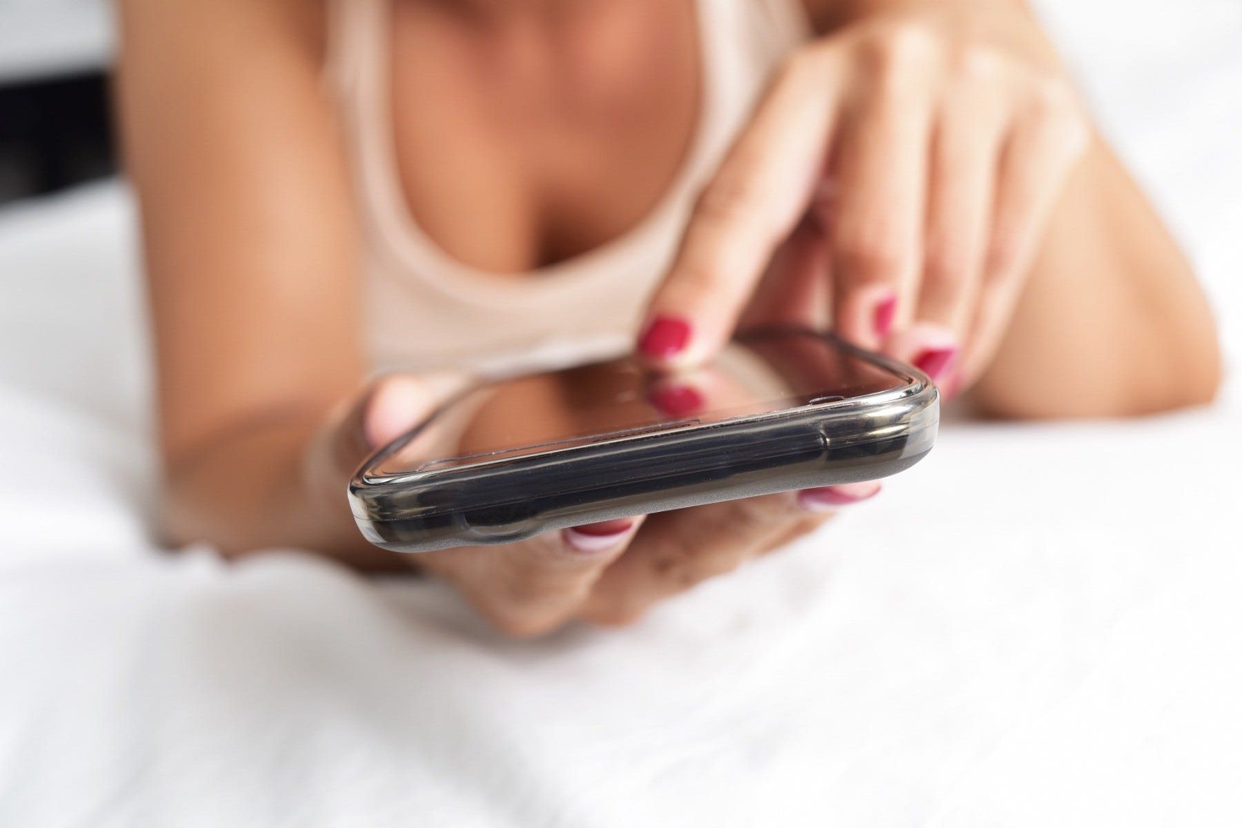 A woman on her phone about to have phone sex with her partner