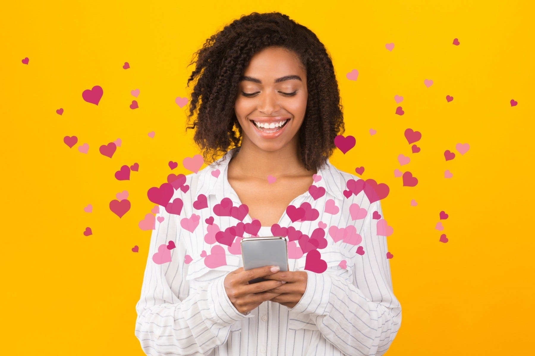 A woman on her phone receiving texts as hearts